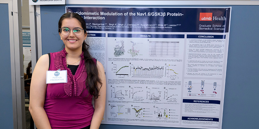 A smiling woman standing in front of a presentation board
